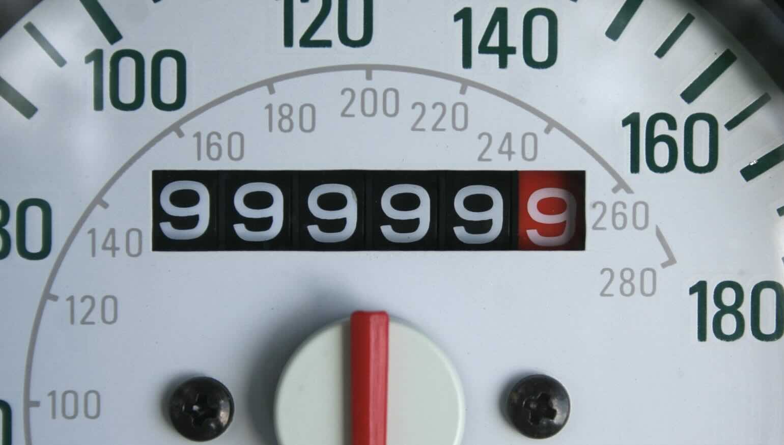 "Close-up photograph of a mechanical car odometer showing the reading 999999 just before it rolls over. The image illustrates a finite counting device that will wrap back to 000000 after one more tick."